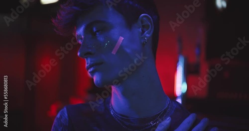 Close up of young gay man with uv makeup at a bar photo