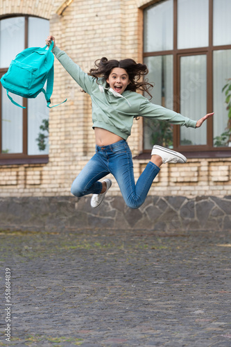 Fototapeta Naklejka Na Ścianę i Meble -  school girl childhood jump outdoor. school girl jump childhood outside. school girl jump
