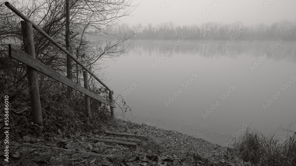 Fototapeta premium Small staircase with wooden railing by the lake in winter