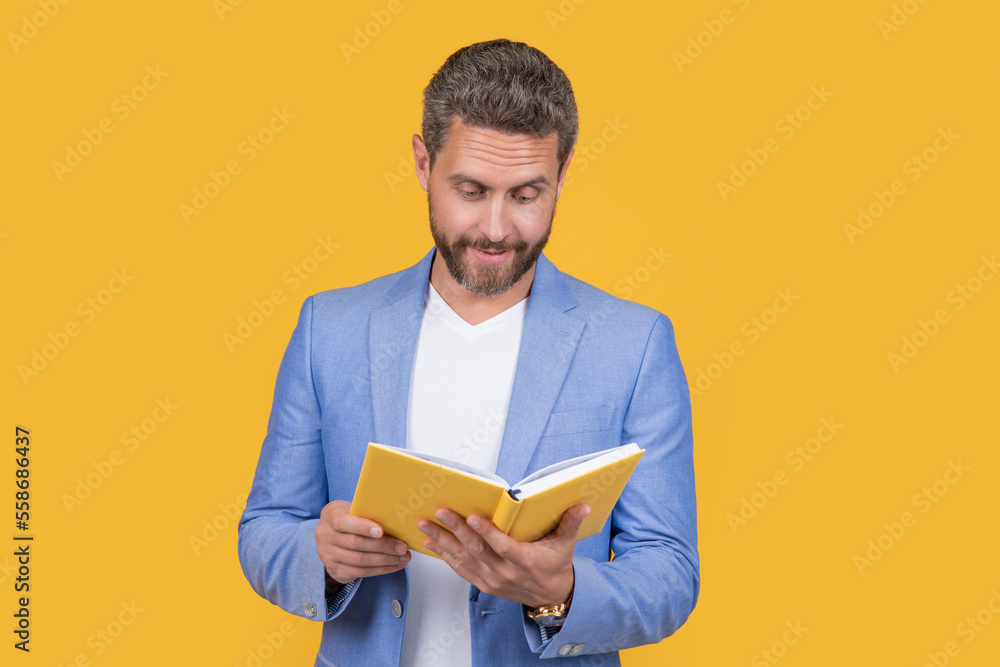 photo of businessman reading planner. businessman reading planner isolated on yellow photo of businessman reading planner. businessman reading planner isolated on yellow
