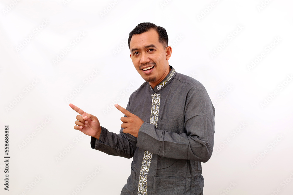 Happy asian man standing while pointing sideways. Isolated on white background Happy asian man standing while pointing sideways. Isolated on white background