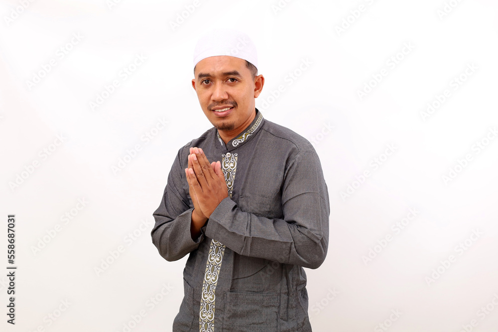 Happy asian muslim man standing with greeting hand gesture. Isolated on white background Happy asian muslim man standing with greeting hand gesture. Isolated on white background