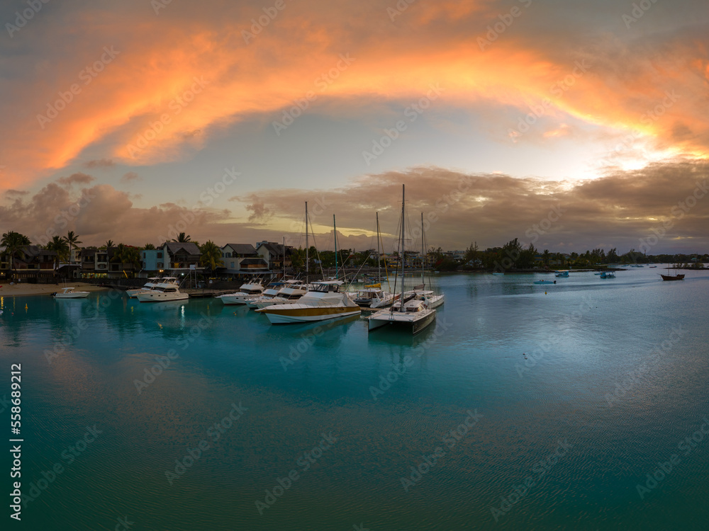 Splendid sunset at Pereybere town in Mauritius. Amazing lights over the ocean. Luxury yacht port and beautiful clear water.