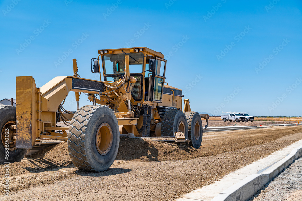 Yellow tractor, construction equipment, road repair.
