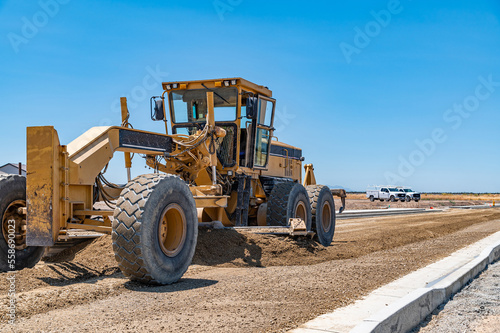 Yellow tractor, construction equipment, road repair.
