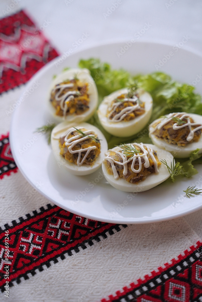 Deviled eggs aka stuffed eggs. Traditional Ukrainian food on the table with embroidered tablecloth.