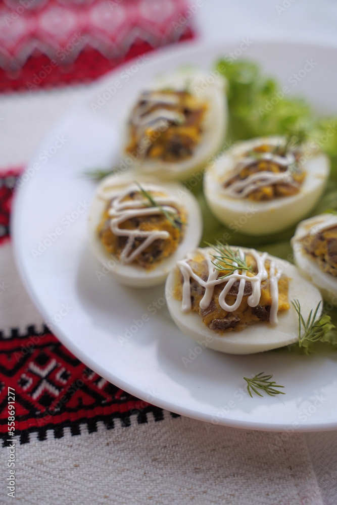 Deviled eggs aka stuffed eggs. Traditional Ukrainian food on the table with embroidered tablecloth.