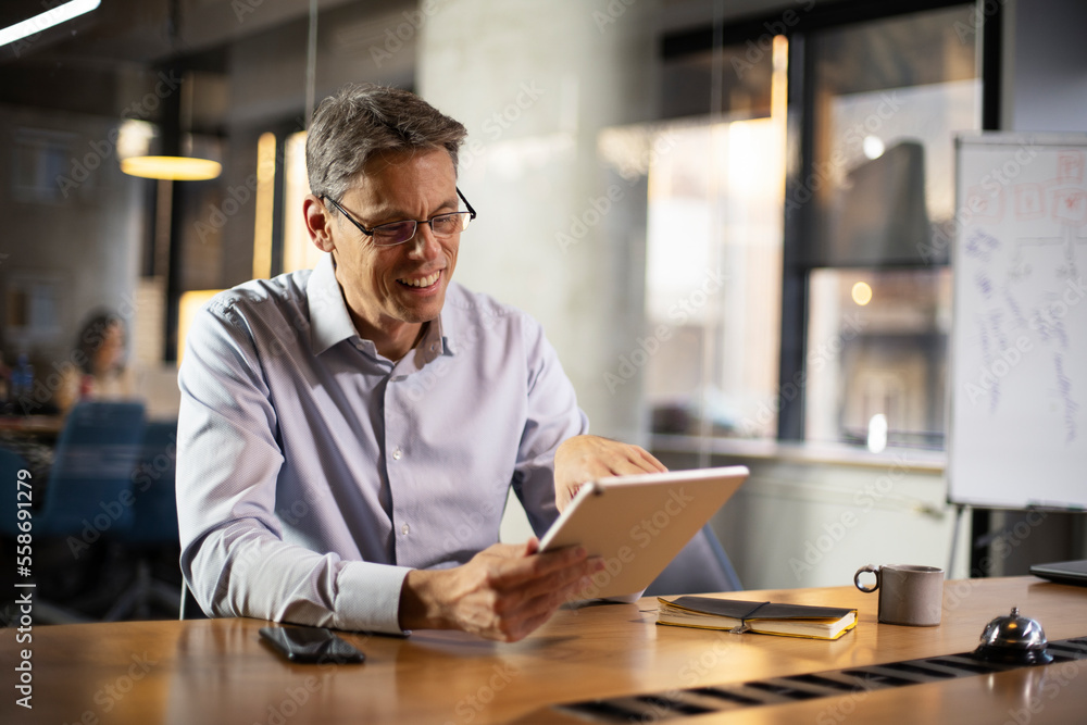 Obraz premium Portrait of businessman in office. Man using digital tablet. Businessman having video call..
