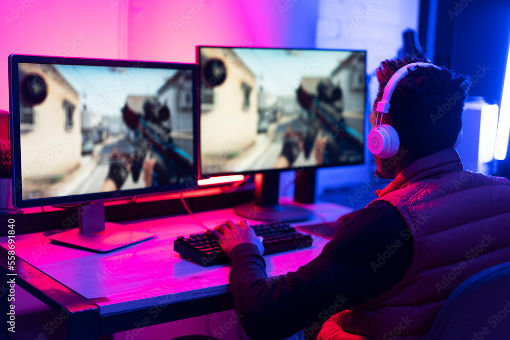 Young African man playing video game on computer. Streamer guy sitting at home and plays another match. Young African man playing video game on computer. Streamer guy sitting at home and plays another match.