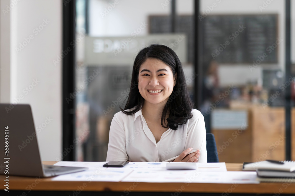 Charming Asian businesswoman sitting in the office with a digital laptop computer. Excited Asian businesswoman raising hands to congratulate while working in a modern office, Charming Asian businesswoman sitting in the office with a digital laptop computer. Excited Asian businesswoman raising hands to congratulate while working in a modern office,