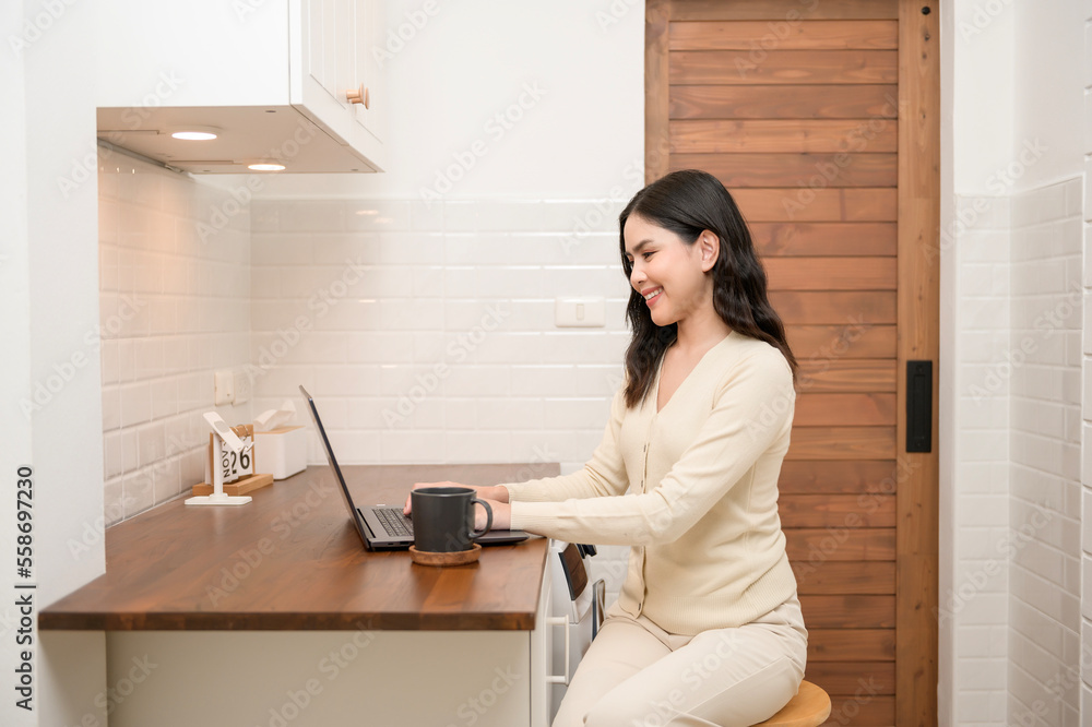 An Asian young woman using laptop computer online working at home , lifestyle and teleworking concept An Asian young woman using laptop computer online working at home , lifestyle and teleworking concept