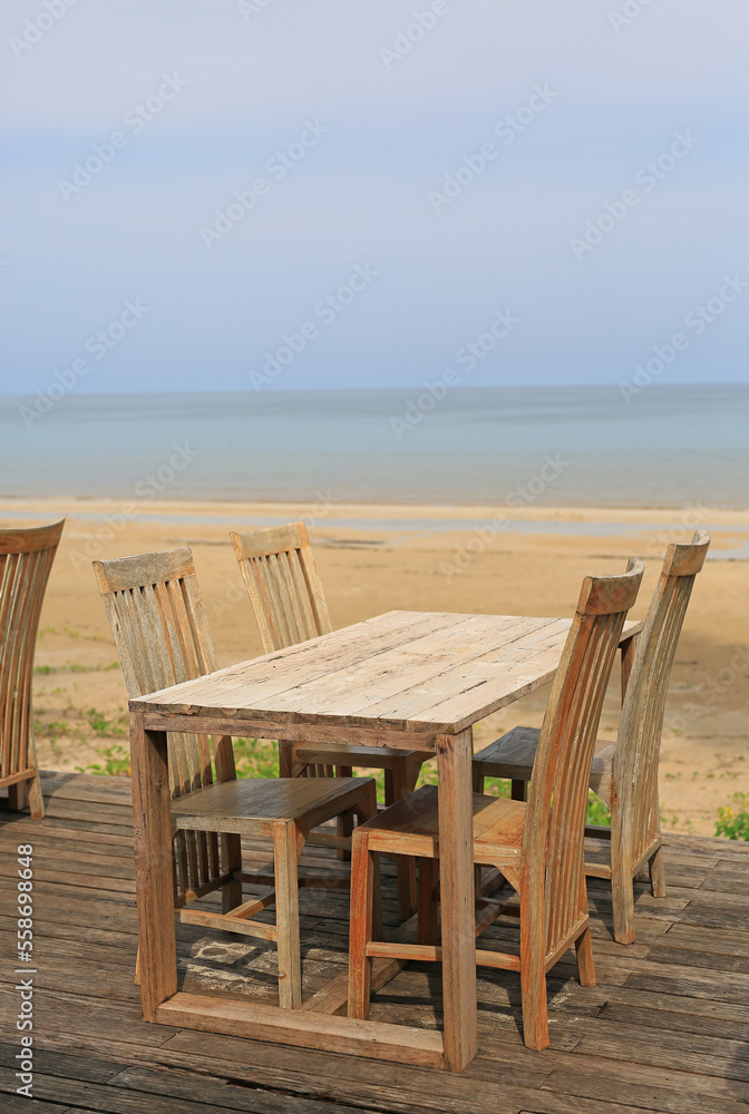 Empty wood table and chairs at restaurants near the beach.