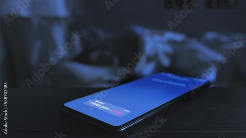 infidelity love affair phone on bedside table shows lover mistress message with couple sleeping on bed,smartphone screen display love note