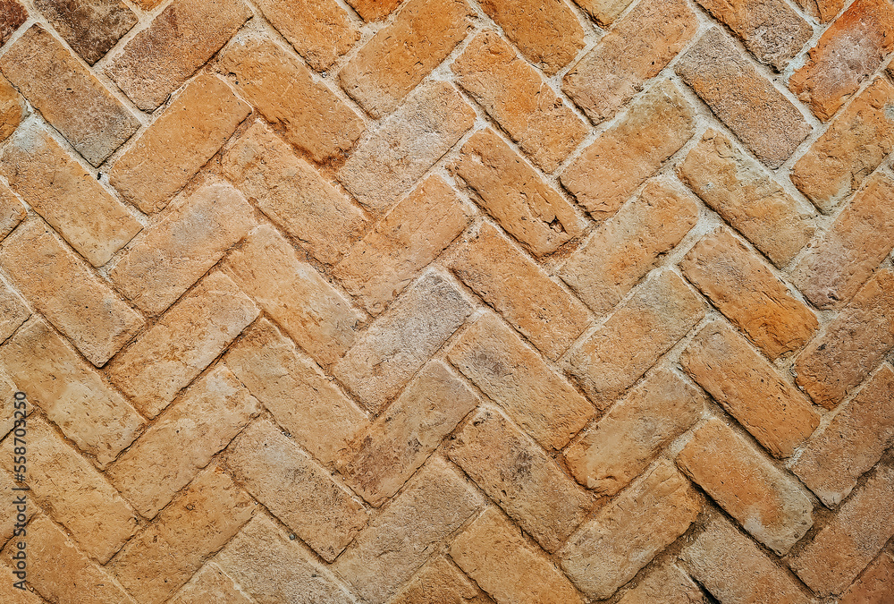 Top view of old bricks paving stones footpath pattern on sidewalk outdoors as brickwork weave texture or abstract stone paver herringbone template background. Top view of pavement surface. Top view of old bricks paving stones footpath pattern on sidewalk outdoors as brickwork weave texture or abstract stone paver herringbone template background. Top view of pavement surface.