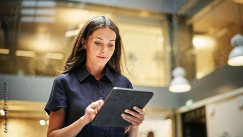 Foto Portrait of a Powerful Female Leader Checking Meeting Briefing on her Tablet and Walking in Busy Corporate Office