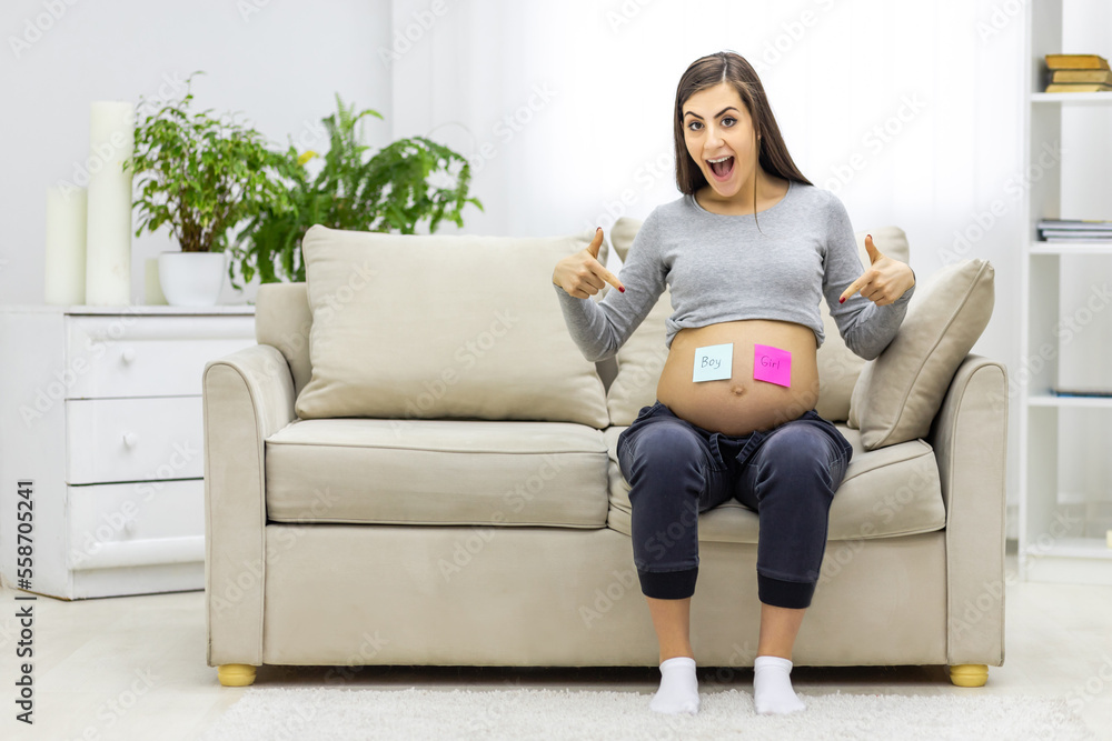 Photo of positive pregnant woman with pink and blue papers on the stomach which mean gender of future baby. Photo of positive pregnant woman with pink and blue papers on the stomach which mean gender of future baby.