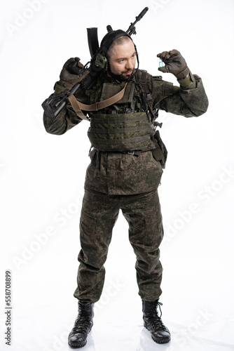 soldier in the studio on a white background. a man in military uniform with a rifle or machine gun. military or airball player