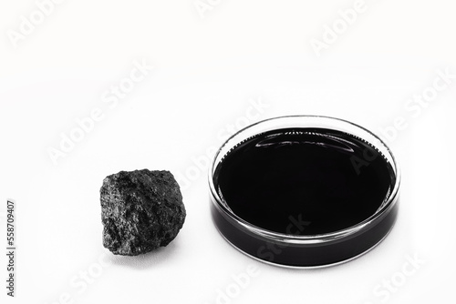 petri dish with petroleum, fuel oil, isolated white background, with stone petroleum coke ore, petroleum products and refined products, industrial use