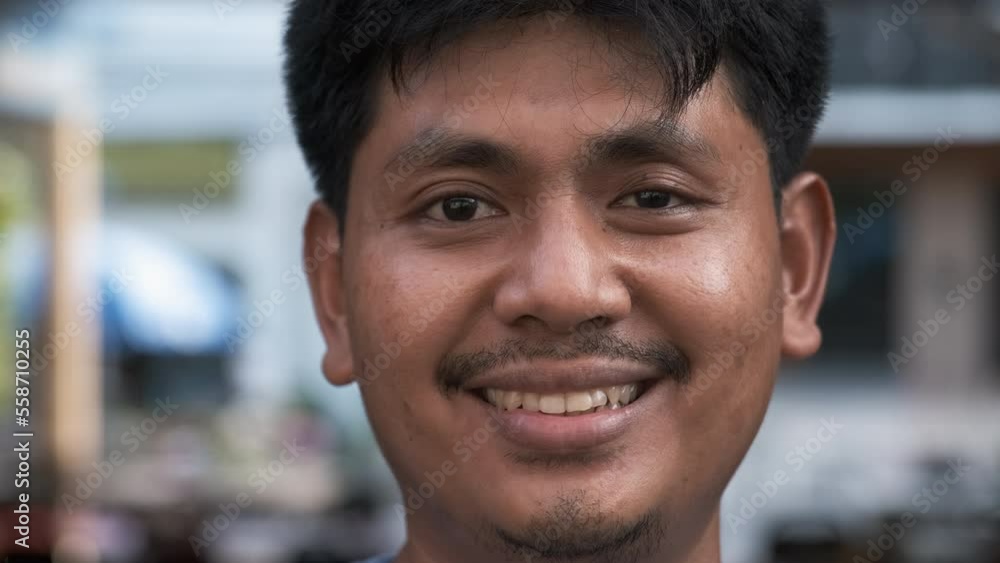 Portrait of smiling asian man with mustache, taken outdoors in the street outside. Dark skin, Thai nationality. Concept of race and nation diversity Portrait of smiling asian man with mustache, taken outdoors in the street outside. Dark skin, Thai nationality. Concept of race and nation diversity