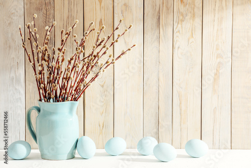 Fotografia Easter eggs and vase with first willow flowers on white table