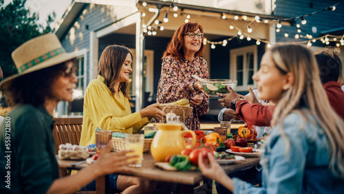 Family and Multiethnic Diverse Friends Gathering Together at a Garden Table. People Eating Grilled and Fresh Vegetables, Sharing Tasty Salads for a Big Family Celebration with Relatives.