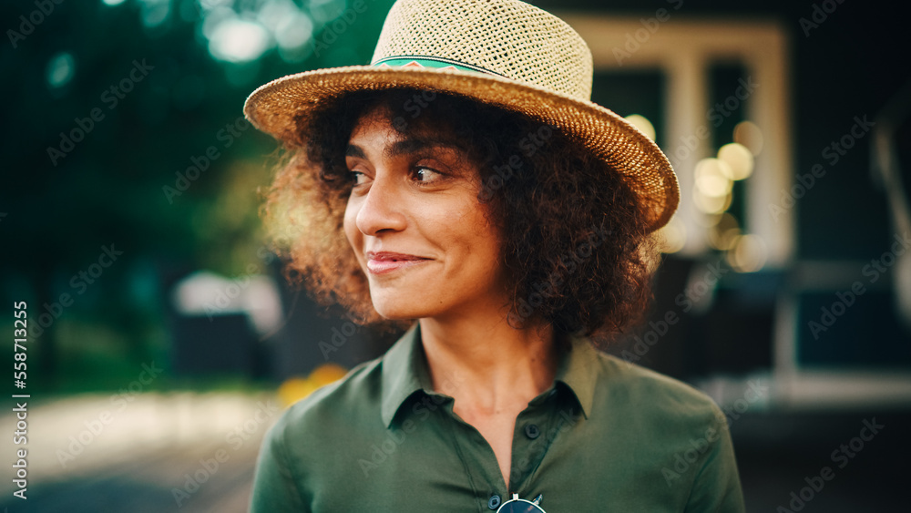 Portrait of a Happy Multiethnic Female Smiling Sincerely, Laughing and  Looking to the Side. Young Female with Curly Hair Wearing a Fedora Hat,  Posing, Expressing Joy and Positive Attitude. foto de Stock
