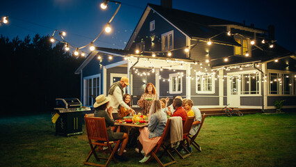 Group of Multiethnic Diverse People Having Fun, Sharing Stories with Each Other and Eating at Outdoors Dinner Party. Family and Friends Gathered Outside Their Home on a Warm Summer Evening.