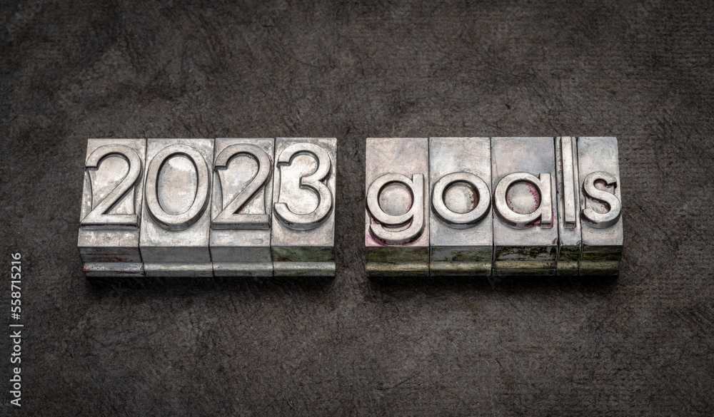 Naklejka premium 2023 goals in grunge metal type against black textured paper, setting goals and resolutions concept