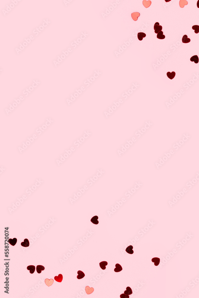 Red confetti in a heart shape on a pink background. Concept with place for text.
