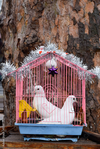 Quadro su tela Cage with white pigeons near the trunk of a tree