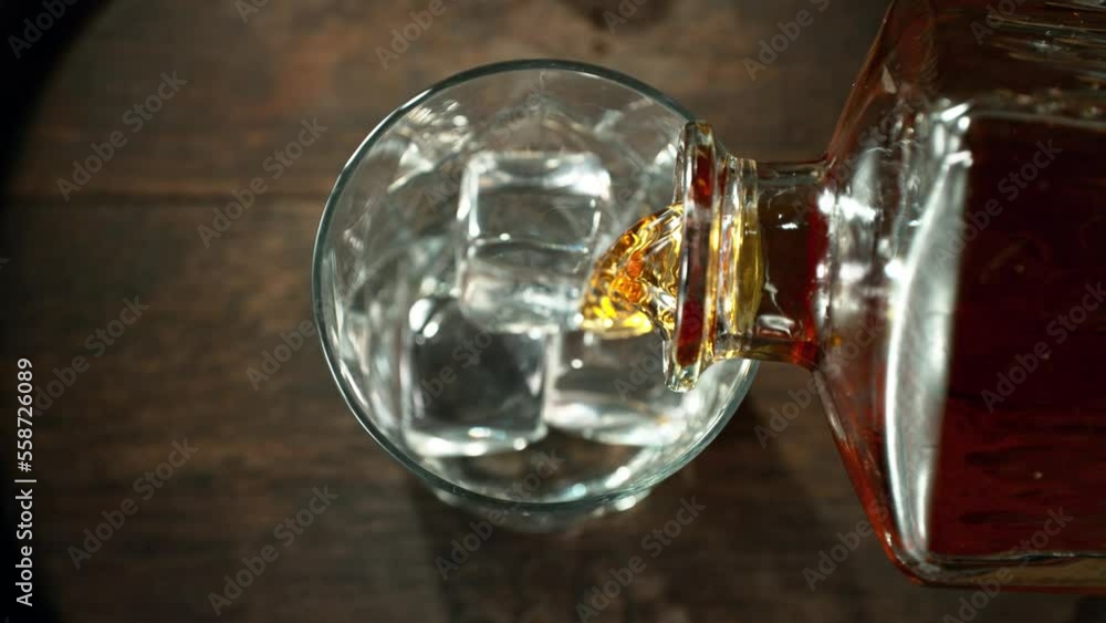 Super slow motion of pouring whisky into glass with speed motion. Filmed on high speed cinema camera, 1000 fps, placed on high speed cine bot. Super slow motion of pouring whisky into glass with speed motion. Filmed on high speed cinema camera, 1000 fps, placed on high speed cine bot.