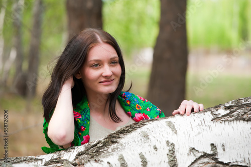 Young beautiful woman near birch photo