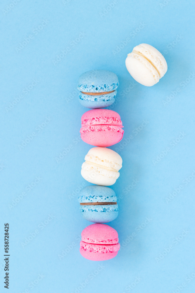 Fototapeta premium Colorful macaron food art, empty space on blue background
