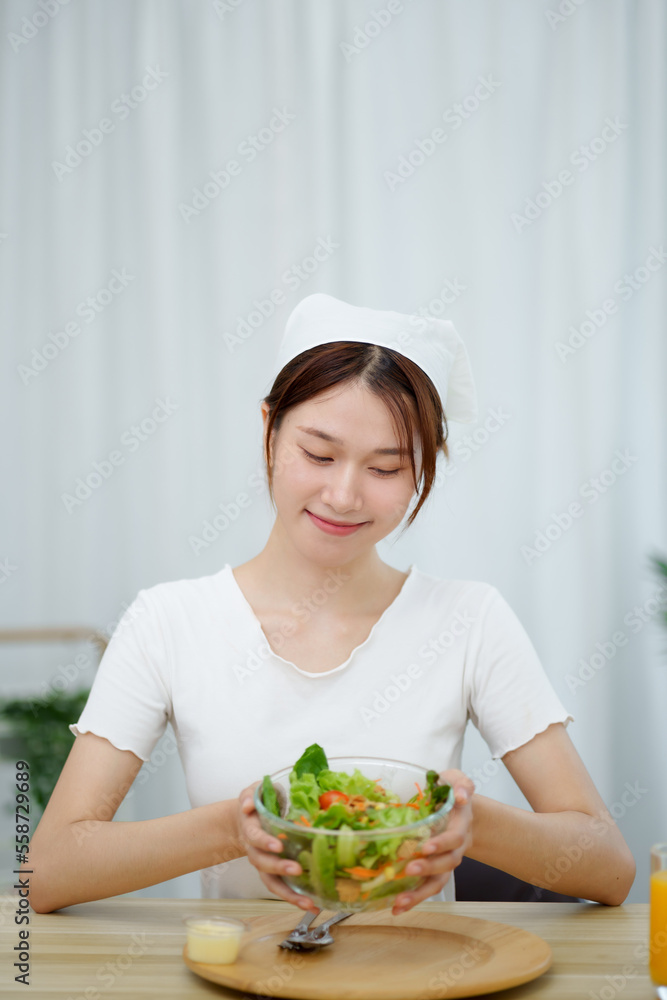 Cheerful young Asian woman happy eating healthy food Cheerful young Asian woman happy eating healthy food