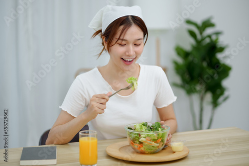 Portrait of happy playful asian girl eating fresh salad in diet concept