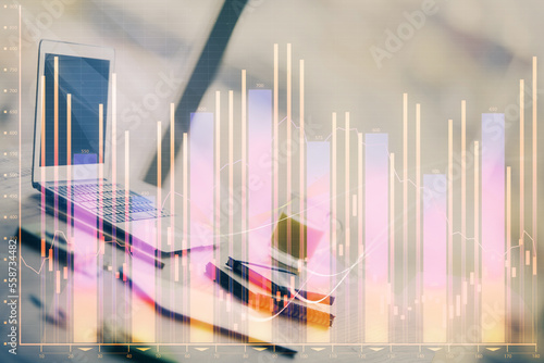 Stock market graph on background with desk and personal computer. Double exposure. Concept of financial analysis.