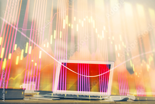 Stock market graph on background with desk and personal computer. Multi exposure. Concept of financial analysis.