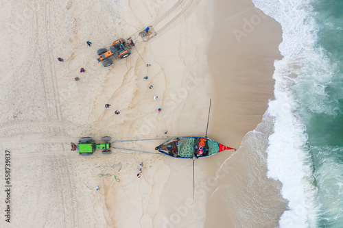 Aerial view of a boat and tractor used for Arte Xavega, a Portuguese traditional fishing technique in Torreira, Portugal. photo