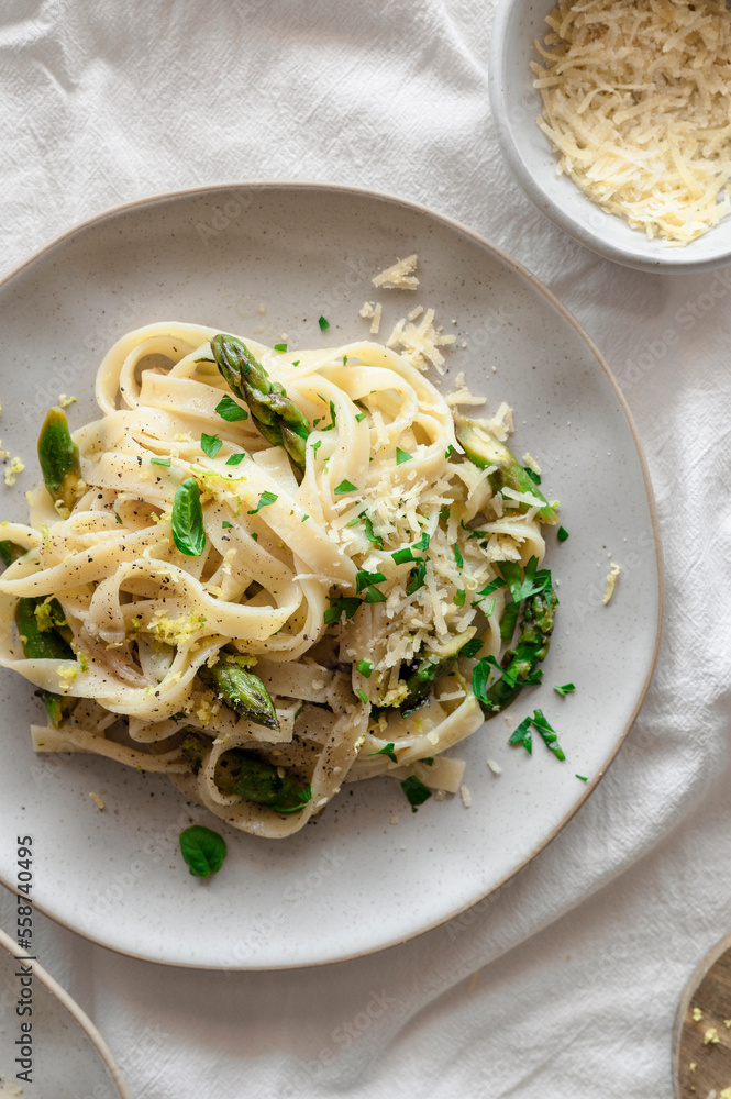 Lemony pasta with asparagus, vegan cheese and fresh basil in a spring airy table Lemony pasta with asparagus, vegan cheese and fresh basil in a spring airy table