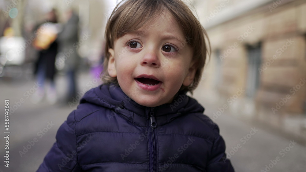 Baby toddler walking in city sidewalk outside during winter Baby toddler walking in city sidewalk outside during winter