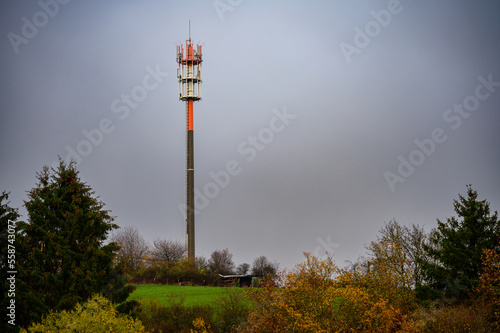 Tall telecommunications and 5G cell tower with microwave antennas in fall