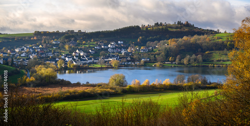 Hillside town of Schalkenmehren with volcanic lake and observatory in fall