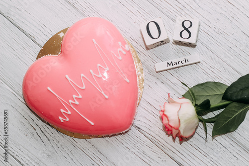 Pink tea rose with heart shaped pink mousse cake and February 14 calendar.
