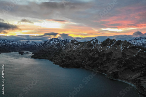 Aerial view of a mountain range with snow on the crests along the Dutch Harbour on Amaknak Island at sunset, Unalaska, Alaska, United States. photo