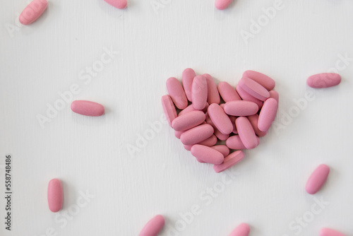Pink Prenatal Vitamins in the shape of a heart, healthy pregnancy, motherhood concept, multivitamin pills, pink heart pills, pink heart vitamins on white background
