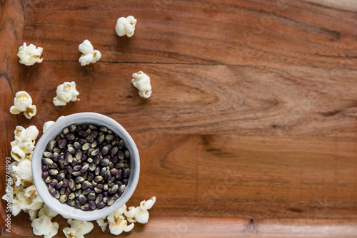 Blue popcorn kernels in white bowl on wood background, healthy snack, popcorn kernels, healthy eating, copy space