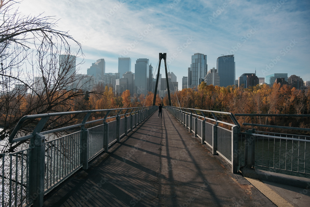 Fototapeta premium Man on the footbridge taking photos of the city of Calgary in Alberta, Canada.