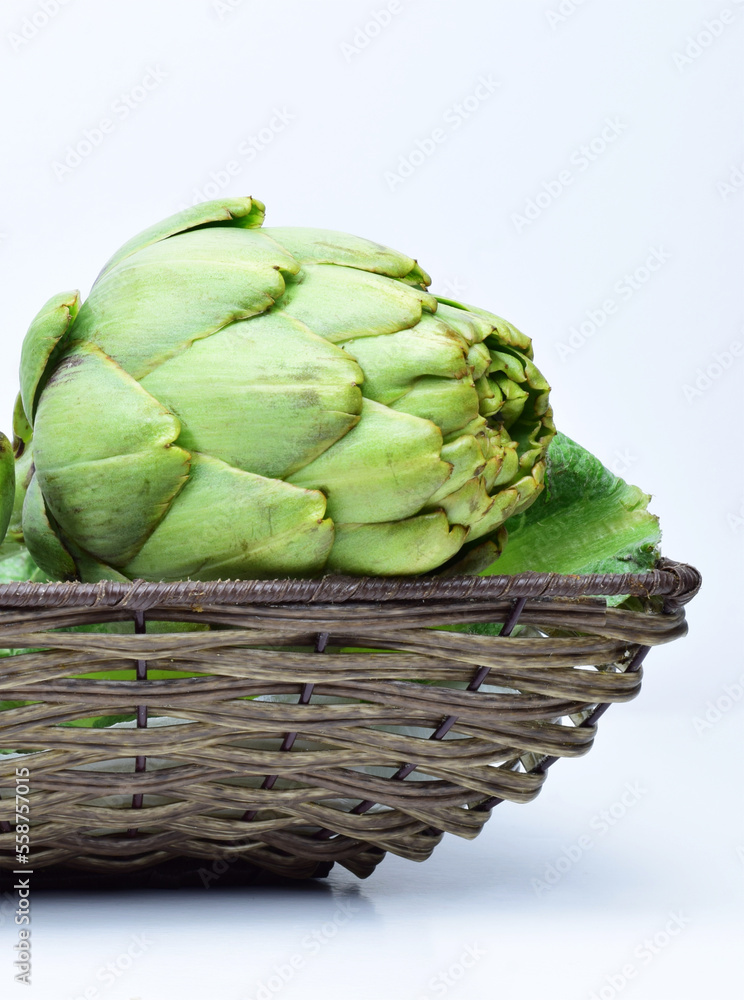 Close up. Wicker basket with artichokes, light background. Close up. Wicker basket with artichokes, light background.