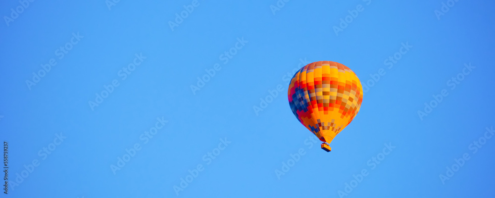 Fototapeta premium Flying hot air balloon against bright blue sky