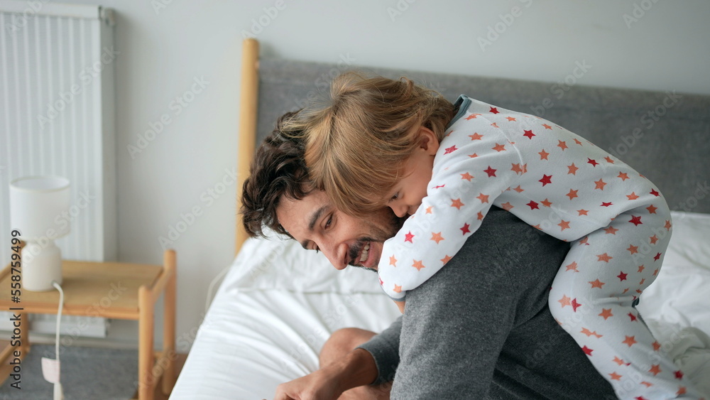 Cute baby toddler climbing on father back in the morning bed Cute baby toddler climbing on father back in the morning bed